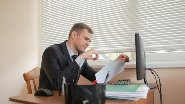 Gerente en la oficina se sienta a la mesa cansado de trabajar — Vídeos de Stock