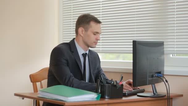 Bir bilgisayar ve ofis belgeleri çalışma çekici iş adamı — Stok video