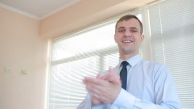 Genç işadamı ofis pencere zemin üzerine çırparak yakışıklı güneşlikler