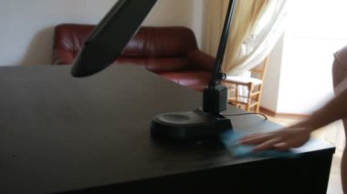 El mavi bir bez tutar ve onun toz masadan mendil