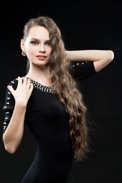 Hermosa mujer con cabello oscuro y maquillaje de noche. vestido negro sexy —  Fotos de Stock