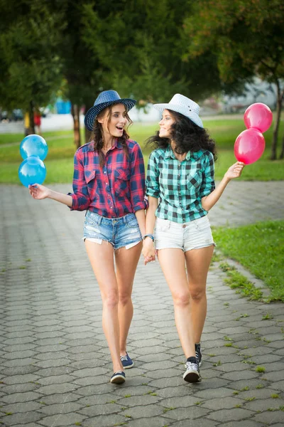 Duas meninas em chapéus de cowboy com balões — Fotografia de Stock