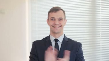 Genç işadamı ofis pencere zemin üzerine çırparak yakışıklı güneşlikler