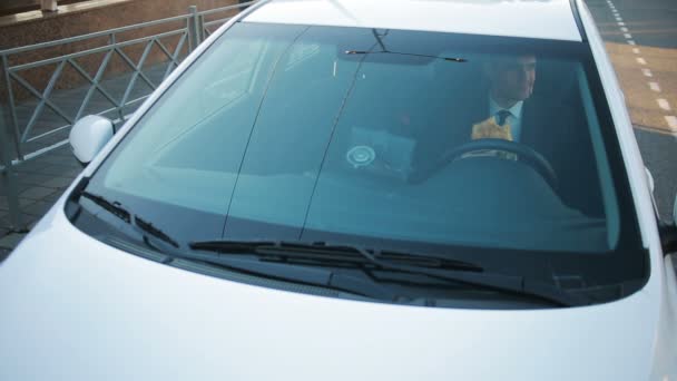 Empresario comiendo comida rápida sentado al volante de un coche — Vídeos de Stock