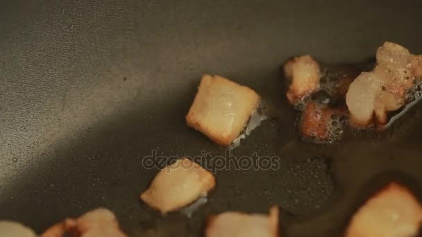 Осколки бекона на горячей сковороде поджариваются. — стоковое видео