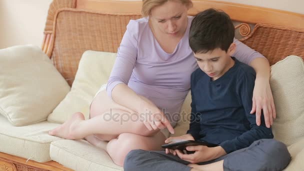 Moeder en haar zoon tiener spreken goed, kijk bij de aanraking van de tablet het touchscreen — Stockvideo