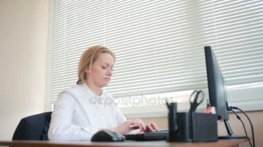 Bir bilgisayar ve Office belgeleri ile çalışan çekici kadın