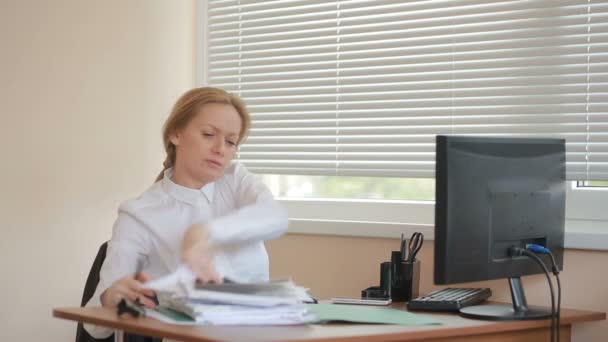 Привлекательная деловая женщина, работающая с компьютером и документами в офисе — стоковое видео