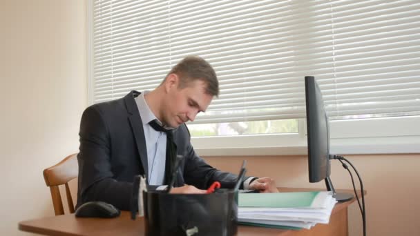 Менеджер в офисе сидит за столом устал от работы — стоковое видео