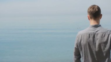 İşadamı elbiseli bir plaj boyunca elini kolunu sallaya dönüyor. güzel plaj hayran