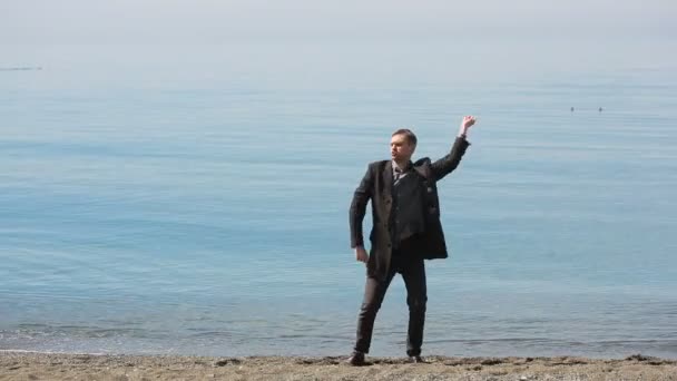 Empresario de traje. Danzas Admira la hermosa playa . — Vídeos de Stock