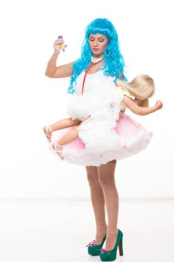 mavi saçlı genç kız bebek. Bir oyuncak şırınga elinde tutar. Enjekte