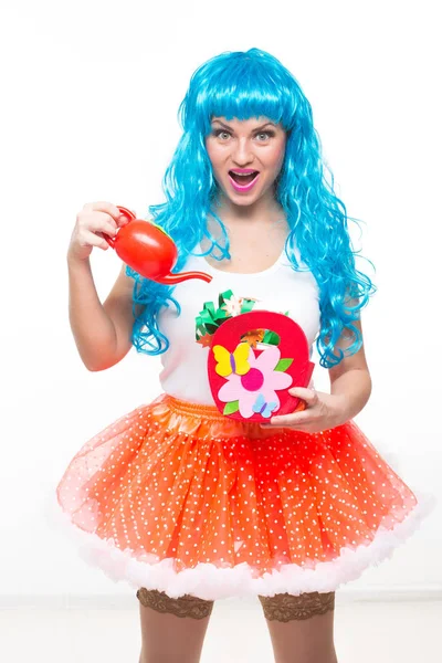 Кукла с голубыми волосами. полив искусственные цветы — стоковое фото