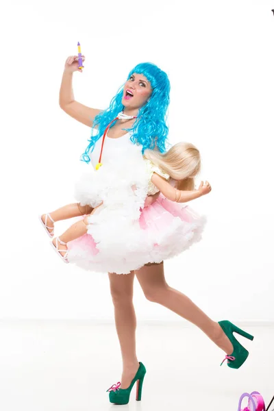 Mladá dívka panenku s modrými vlasy. Má toy stříkačkou v ruce. Injekčně — Stock fotografie