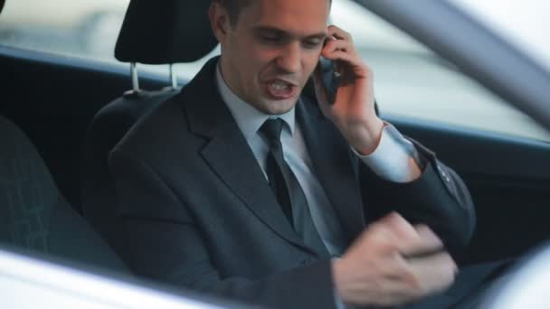 Geschäftsmann im Auto, am Telefon fluchend. — Stockvideo