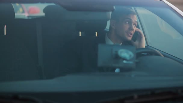 Бизнесмен в машине разговаривает по телефону . — стоковое видео