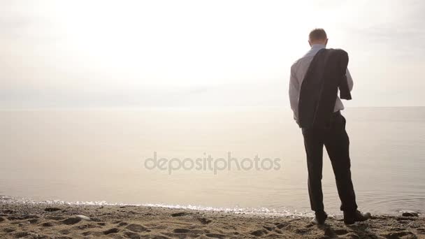 Zakenman in pak permanent op strand en gebaren uit te nodigen om toe te treden zelf — Stockvideo