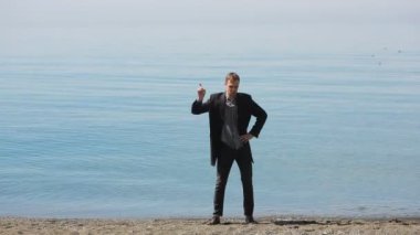 Takım elbiseli bir iş adamı. Dans etmek güzel plaj hayranım.