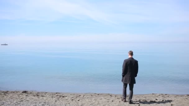Empresario pasea por la playa en un traje. admira la hermosa playa — Vídeos de Stock