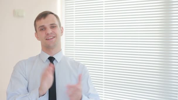 Jonge knappe fladderende zakenman in kantoor op de achtergrond van het venster met jaloezieën — Stockvideo