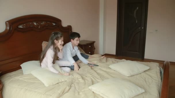 Hermano y hermana pelean y se empujan en casa en el dormitorio de los padres. luchando por el teléfono — Vídeos de Stock
