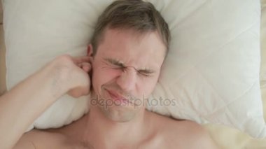 Bir adam bir yatak çizikler kulağı, yakın çekim yer almaktadır. Yukarıdan görüntülemek