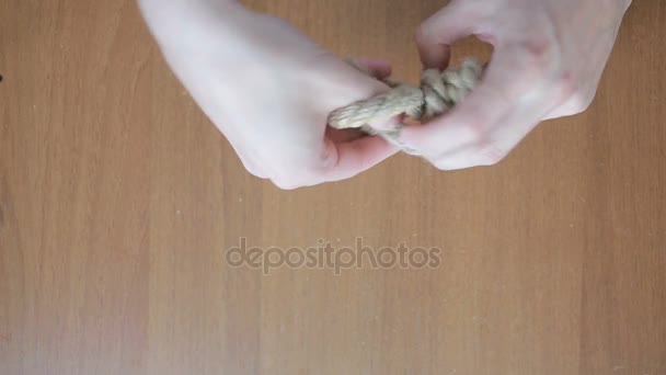 Hands of a man knotting a knot on a rope — Stock Video