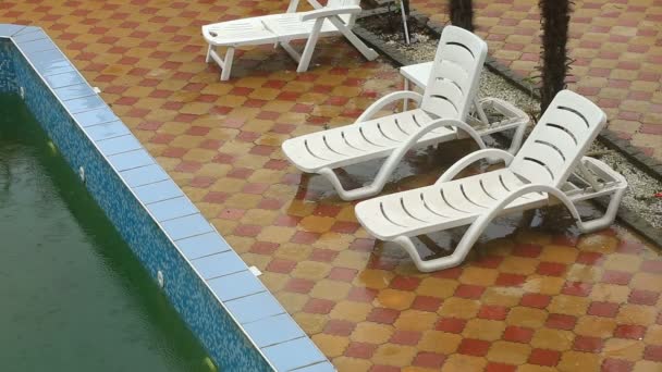 Starkregen fällt in ein Schwimmbad. nicht Saison, schmutzige verlassene Pool — Stockvideo