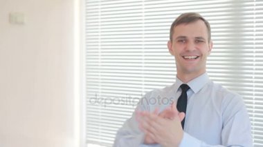 Genç işadamı ofis pencere zemin üzerine çırparak yakışıklı güneşlikler