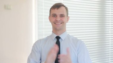 Genç işadamı ofis pencere zemin üzerine çırparak yakışıklı güneşlikler