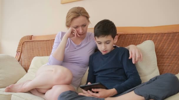 Mamma och hennes son tonåringen tala bra, titta på den tablet touchen pekskärmen — Stockvideo