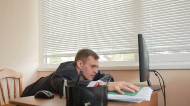 Ofis Yöneticisi çalışmalarını yorgun masada oturur