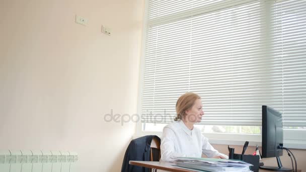 Attractive business woman working with a computer and documents in the office — Stock Video