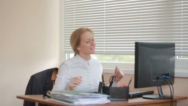 Жінка-менеджер втомилася працювати за столом в офісі і танцює — стокове відео