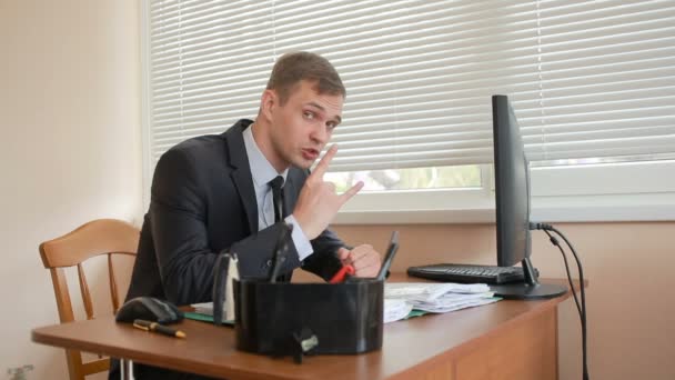 Gerente en la oficina se sienta a la mesa cansado de trabajar — Vídeos de Stock