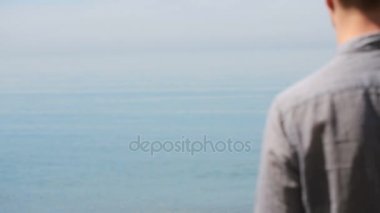 İşadamı elbiseli bir plaj boyunca elini kolunu sallaya dönüyor. güzel plaj hayran