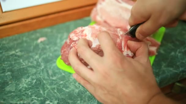Mužské ruce řez syrové maso na steaky na prkně. Detail. — Stock video