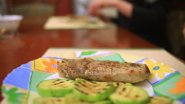Ein Mann isst zu Hause im familiären Rahmen ein Steak. Nahaufnahme — Stockvideo