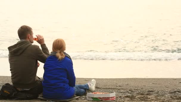 Paar pizza samen eten aan de kust, koud weer, — Stockvideo