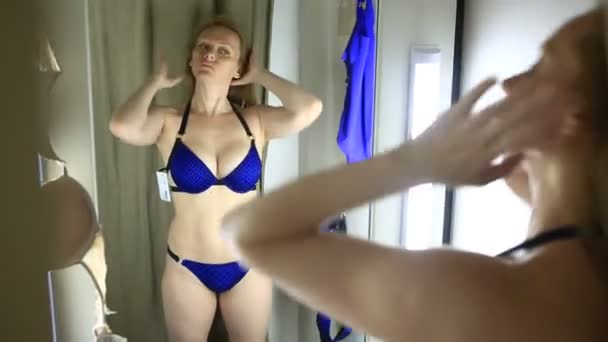 La ragazza sta provando un costume da bagno nello spogliatoio di una biancheria intima femminile — Video Stock