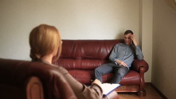 Консультация психолога, женщина-терапевт консультирует пациента с мужчиной с тревожным расстройством, психопатией — стоковое видео