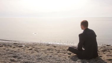 Elbiseli suda taş atan ve mimik sahilde oturan işadamı kendisi katılmak için davet ediyor