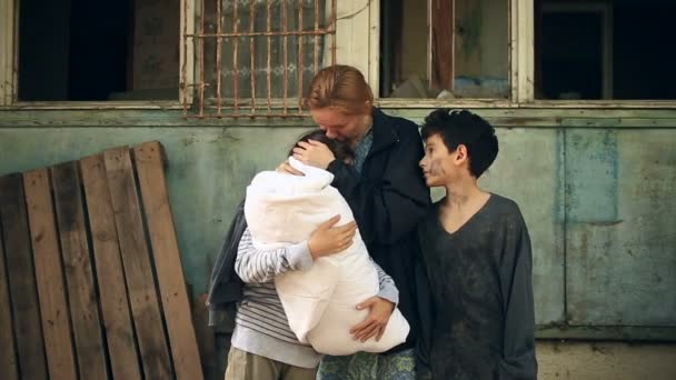 Flüchtlingskinder und ihre Mutter mit einem Kind im Arm vor dem Hintergrund zerbombter Häuser. Krieg, Erdbeben, Feuer — Stockvideo