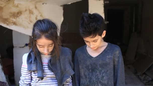 Flyktingbarn mot bakgrund av bombade hus. Krig, jordbävning, brand — Stockvideo