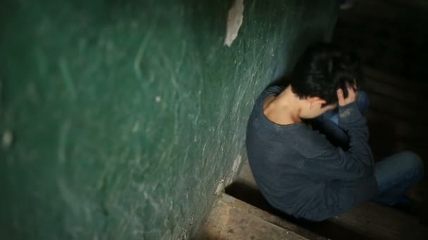 De jongen zit op de trappen van een verlaten veranda. Het concept van childrens drugsverslaving, landloperij, dakloosheid. — Stockvideo
