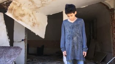 Mülteci çocuklar harap bir ev oturuyorsun. Savaş, deprem, yangın, bombalama. Çocuk genç
