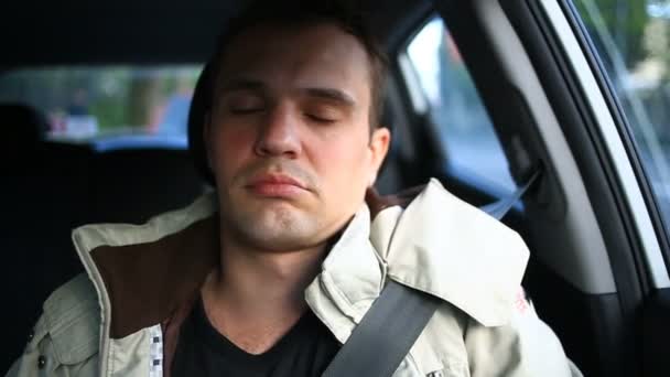 Sterownik człowieka zasnął na siedzeniu kierowcy po stronie ruchliwej ulicy. Czeka w samochodzie — Wideo stockowe