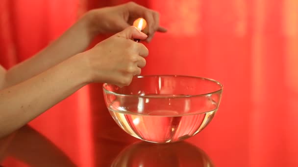 Divination with candle. woman pouring wax into the water. Divination with candle. Woman pouring wax into the water. Melt the wax over the candle flame — Stock Video