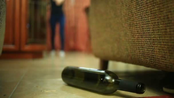 Wanita minum alkohol, wanita dengan botol di tangan. Botol kosong alkohol di bawah latar belakang seorang wanita tergeletak di lantai . — Stok Video