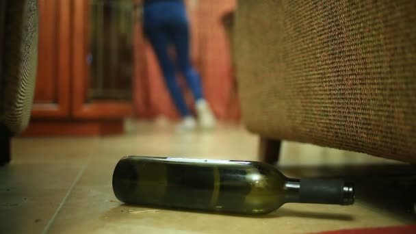 Mujer bebiendo alcohol, mujer con la botella en las manos. Botella vacía de alcohol bajo el fondo de una mujer acostada en el suelo . — Vídeos de Stock